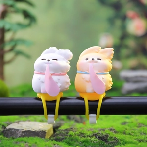Figurines de renard mignonnes blanches et orange fixées sur un guidon de vélo noir