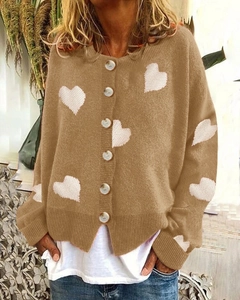 Close-up detail of khaki knit cardigan with white heart patterns and single-breasted buttons