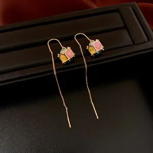 Elegant 18K gold-plated long tassel earrings with colorful stones on black leather