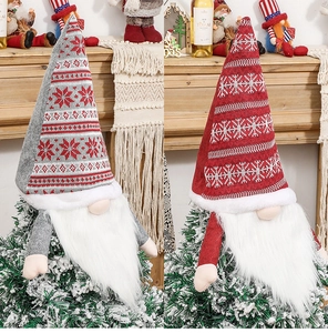 Detail of red and grey knitted Christmas gnome tree toppers with snowflake patterns