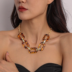 Close-up of leopard print acrylic chain link necklace worn on model for autumn winter style
