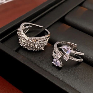 Detailed macro shot of teardrop zircon adjustable silver rings on black leather display