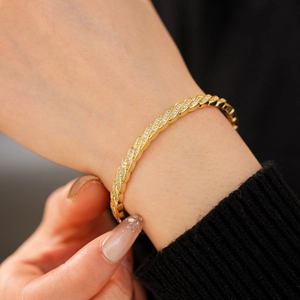 Detailed close-up of a twisted gold-plated bangle featuring micro-set sparkling zircon stones