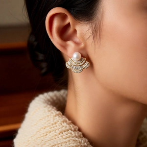 Close-up of fan-shaped pearl earrings with gold plating and zircon inlay on model