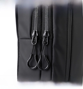 Detail view of smooth dual U-shaped zipper pullers on water-resistant black sling bag