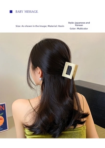 Detail view of large matte coffee resin shark hair claw clip on brunette wavy hair