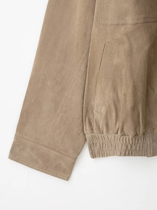 Détail de la veste en daim kaki avec ourlet côtelé et texture de la poche latérale
