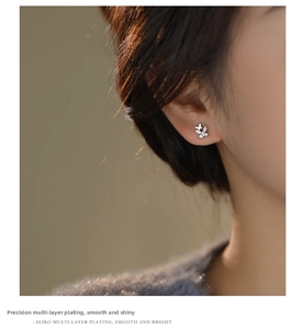 Close-up of sparkling zircon double butterfly earrings in s999 sterling silver on ear