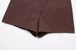 Detailed close-up of brown shorts featuring precise stitching and clean hemline finish