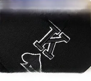 Detailed close-up of high-quality embroidered spade K logo on black baseball cap fabric