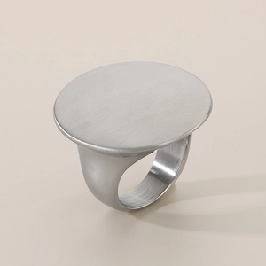 Detail of silver round flat signet ring with brushed metal texture and mirror polish finish