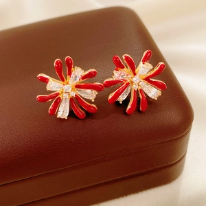 Macro shot of red floral stud earrings with cubic zirconia on a brown leather jewelry case