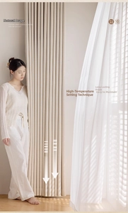 Detail of cream linen textured blackout curtains with elegant vertical pleats and heavy drape