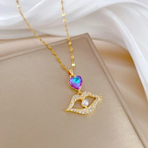 Detailed shot of golden lip necklace with heart crystal and white pearl on silk
