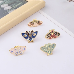 Five assorted creative enamel butterfly and moth brooches on a clean white background