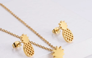 Macro view of gold pineapple jewelry set with hollow grid pattern on the pendant