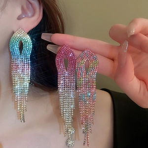 Close-up of long tassel earrings with colorful gradient rhinestones on model
