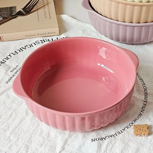 Detailed top view of pink ceramic bowl with double handles and ribbed exterior texture