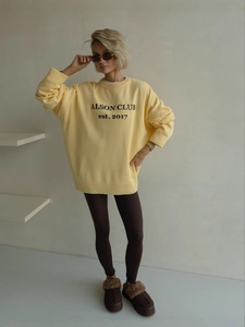 Bright yellow crewneck knit sweater with ALSON CLUB lettering and ribbed cuffs