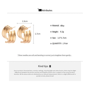 Macro detail of wave textured gold hoop earrings featuring geometric curved alloy design