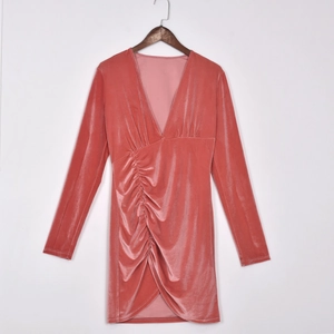 Détail d'une robe en velours rose avec décolleté en V profond et plis à la taille
