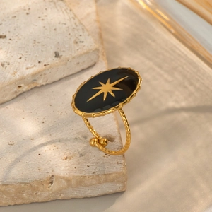 Adjustable black enamel ring with gold starburst and twisted band on stone