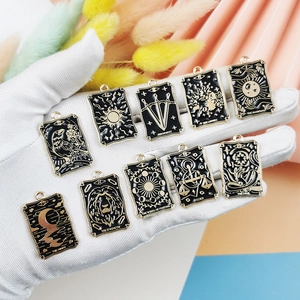 Set of 10 gold-plated tarot card enamel charms held in hand for DIY jewelry making