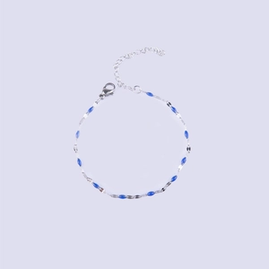 Macro detail of stainless steel silver chain bracelet with blue enamel oval beads and clasp