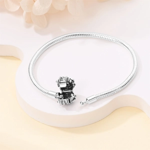 Close-up of silver snake chain bracelet showing detailed texture and gear clasp closure