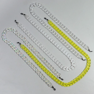 Makro-Detail von Brillenketten aus Acryl in klar, neongelb und irisierend