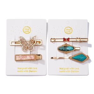 Detail of metal hair clip set with butterfly motifs and turquoise stone texture