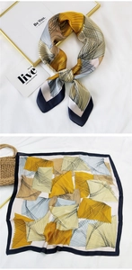 Detailed view of geometric silk square scarf with yellow and navy abstract patterns