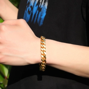 Close-up of golden Cuban link bracelet on wrist with polished glossy metallic finish