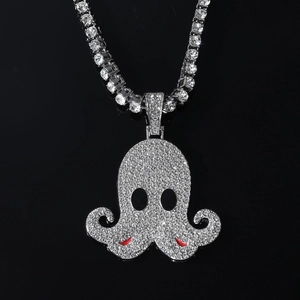 Close-up of a silver octopus pendant with clear rhinestones and red accents on a tennis chain