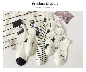 Detail view of 5-pack white and black cat-themed mid-calf socks with cute artistic patterns