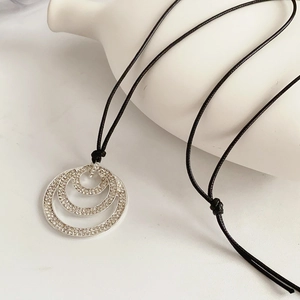 Detail of multi-layer geometric pendant necklace with silver finish and crystal pavé
