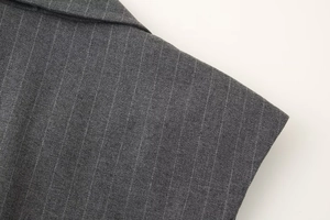 Gros plan sur le tissu gris foncé à rayures d'un tailleur pantalon avec gilet sans manches