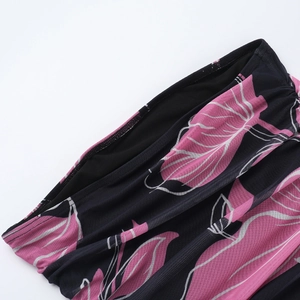 Close-up of tropical pink leaf print on navy ruched mesh sleeveless dress fabric