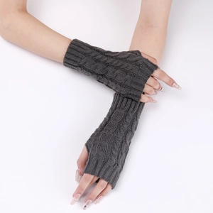 Macro detail of dark grey cable knit texture and thumb hole on the fingerless sleeve