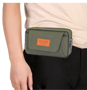 Detail of army green canvas waist bag with orange logo and triple zipper pockets