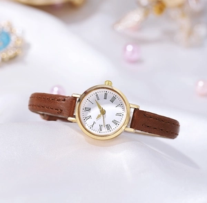 Macro detail of gold case watch with white Roman dial on elegant silk background