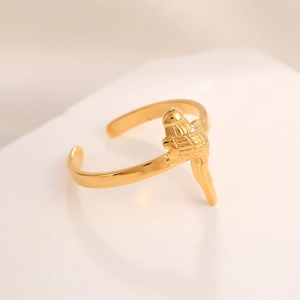 Close-up of golden stainless steel open ring featuring a 3D bird relief and textured art