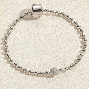 Detail of silver bead chain bracelet with a pave-set crystal ball and barrel clasp