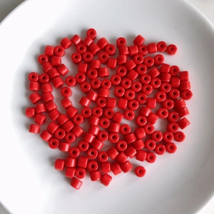 Close-up of vibrant red cylindrical acrylic spacer beads for DIY jewelry making