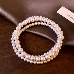 Detail of elegant double-layer pearl bracelet with sparkling rhinestone clasp and beads