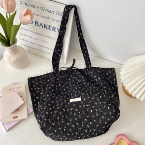 Detail of floral chiffon tote bag with bubble texture and yellow flower patterns on black