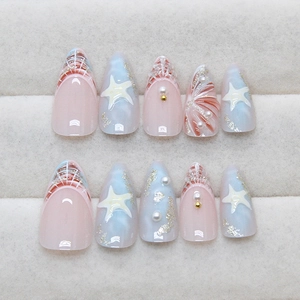 Medium almond press-on nails featuring blue 3D starfish, pearls, and ocean glitter design