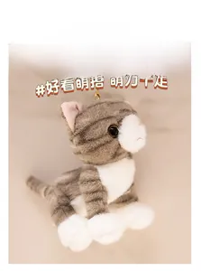 Detail of grey tabby plush cat keychain with golden metal clasp and soft fur texture