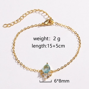 Detail of gold water-drop bracelet with blue gemstone and surrounding crystals
