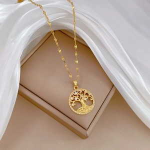 Elegant gold Tree of Life necklace with sparkling crystals on a white silk backdrop